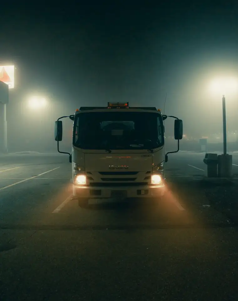 Truck with headlights on a misty night road
